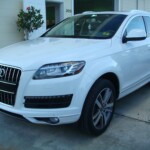 Before and after photographs of a damaged white, AUDI Quattro SUV that was repaired by Elite Paint & Body Shop in West Palm Beach, Florida.